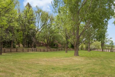 Green Lawns, Trees, and Fencing Line the Property