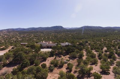 Aerial view of house with Sangres and Santa Fe ski basin in background
