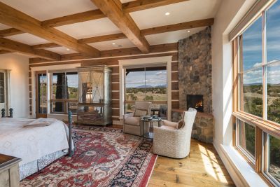 Master Bedroom - Sitting Area with Raised River Rock Fireplace, and Sweeping Views of the Sangre de Cristo Mountains, Fairway & Lake below.