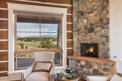 Master Bedroom Vignette of the River Rock Fireplace, Looking out to Fairway & Sangre de Cristo Mountain Views.
