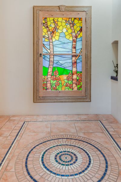 Inside, a lit stained glass window and mosaic floor greet your guests.