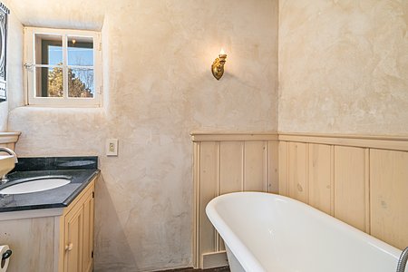 Clawfoot tub and plaster walls in Master bath.