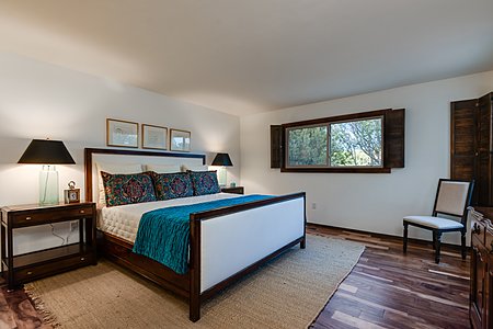 The Generous Master Bedroom with Hardwood Floors is Shown with a King Sized Bed