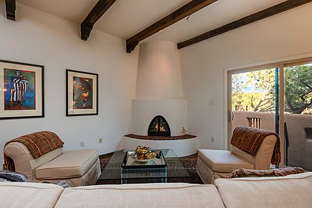 The Raised Kiva Fireplace Has a Brick Hearth and Custom Iron & Glass Doors 