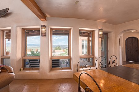 View to outdoor dining/entertaining area with hot tub and views of Abiquiu Lake
