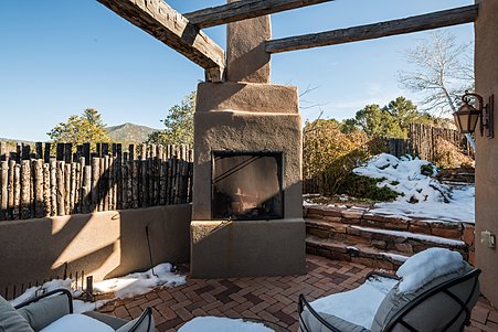 Outdoor kiva fireplace and pergola on large patio