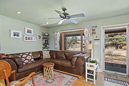 Living area with ceiling fan, and original wood floors throughout