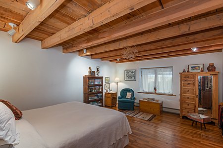 Large Master Bedroom with Wood Floors and Beamed Ceiling