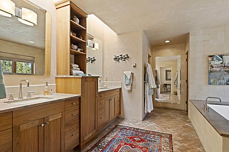 Skylights Wash the Wall of Double Vanity with Walnut Cabinetry & Stone Counters
