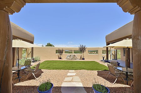 Central courtyard entertaining area with covered portal and yard can be accessed from three sides of the home