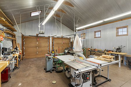 Dual garage doors lead to a spacious workshop area