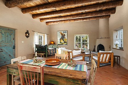 The guest house dining area, with a kiva fireplace, and brick floors