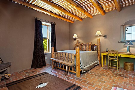 The detached guest suite has a private entrance with brick floors, kiva fireplace, and a bathroom