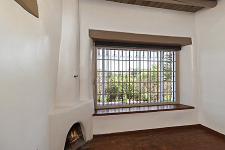 Lovely adobe office with high ceilings, deep picture window seat, views, corner kiva fireplace.