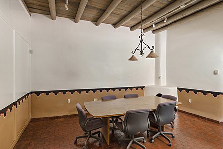 Stylish conference room with hand painted adobe walls and a fireplace. 