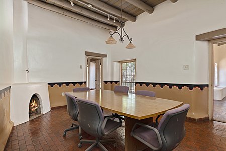 Spacious conference room with fireplace, hand painted walls, and an exterior door