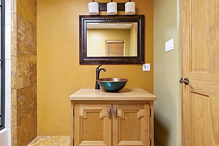 Vanity and vessel sink in en suite bathroom in guest bedroom #1