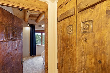Doors with varying carved motifs looking into guest bedroom #2