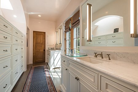 The Owners' Bathroom has Abundant Cabinet Storage and accesses Two Walk-in Closets