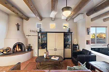 Kiva fireplace in living room/great room with views to the Sangre de Cristo Mountains