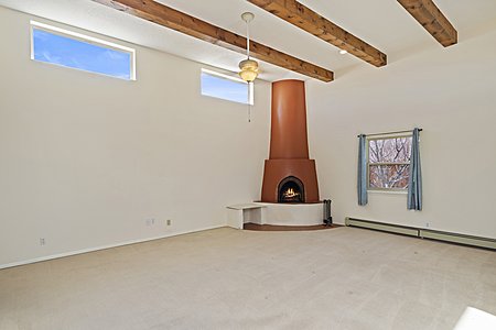 Living room with beams and a Kiva wood burning fireplace
