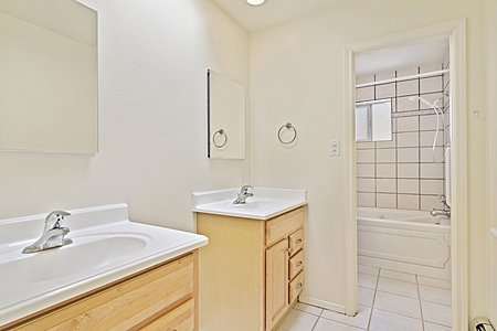 Hall bathroom with double sinks and jacuzzi tub