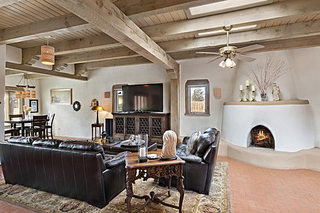 Traditional elegance with brick flooring, corbels, beams and kiva fireplace 