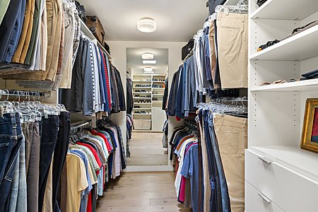 Master suite walk-in closet with built-in shelving and cabinets