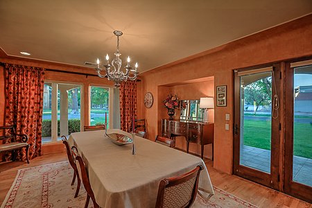 Formal dining room looks out to green views of the park and landscape
