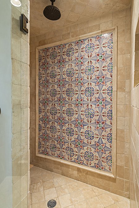 Walk in shower showcasing hand painted Tunisian tile