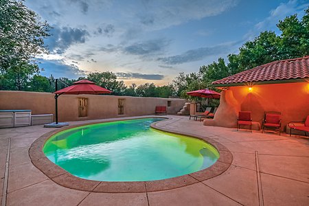 In-ground gunite swimming pool with views of the sunset