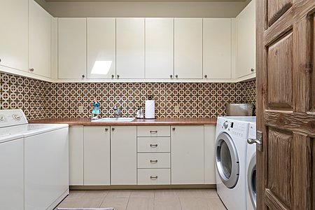 Artisan tiles in the laundry room along with ample storage and two washers and dryers