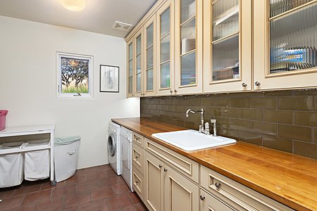 Spacious Laundry Room with Porcelain sink & cabinets with ribbed glass