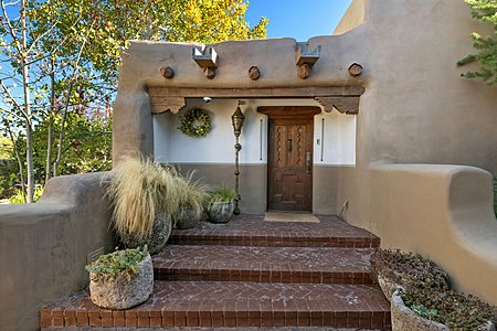 Understated historic elegance in genuine double ADOBE has it all - corbels, lintels, vigas, handcarved door and surrounded by brick patios