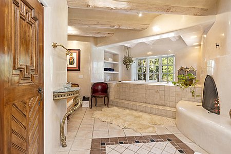 Yes, one can entertain guests in this creamy white travertine marble bath