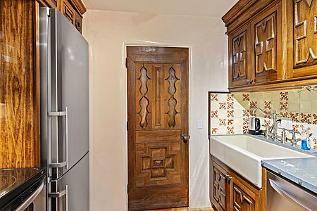 Handcarved cabinetry graces the Guest Suite 2 in main house kitchenette...a laundry is behind the handcarved door