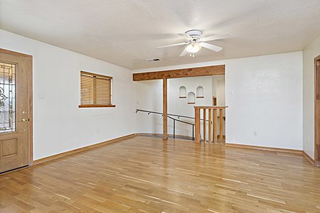 Livingroom with wood flooring looking into hallway.