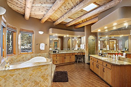 A large jetted soaking tub and two distinct vanities in the Primary Suite bathroom