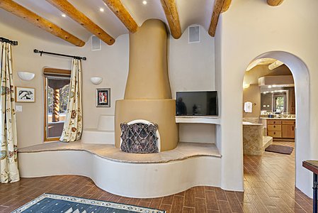 Kiva fireplace with a raised cut stone hearth is a focal point of the Primary Suite