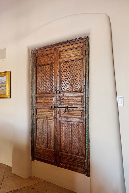 Carved wood doors lead to built in bar in formal living room