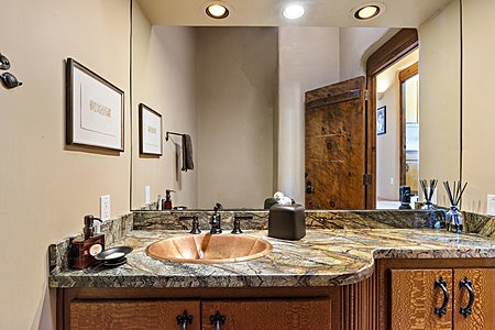 The powder room features an oval copper sink 