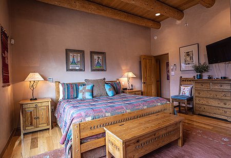 Owners bedroom suite featuring Vigas and wood flooring and views to the Jemez