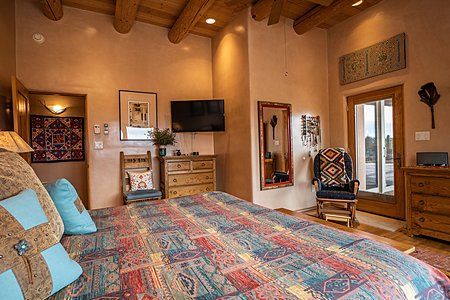 Large owners bedroom suite with door opening onto Portal with views of the Jemez