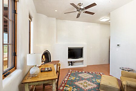 White plaster walls and kiva fireplace in master suite sitting room 