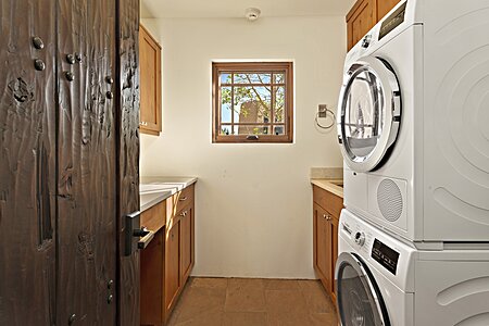 Bright laundry room with long folding counter and sink!