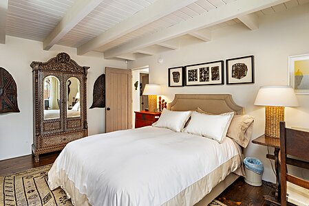 GH Primary Bedroom has white beamed ceilings & wood decking