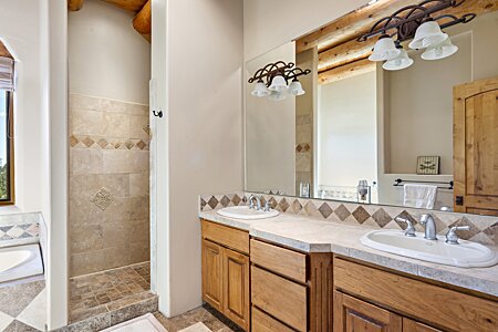 Walk in show with two sink vanity area in primary bathroom.