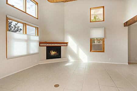 Living room has lots of natural light and high ceiling with vigas.