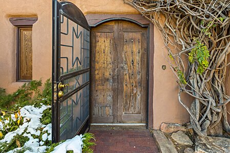 Its an impressive and inviting antique gate in an Adobe entry