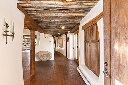 Classic Santa Fe! Glowing brick floors! Latilla ceilings, organic adobe walls, antique doors, and handmade cabinets!